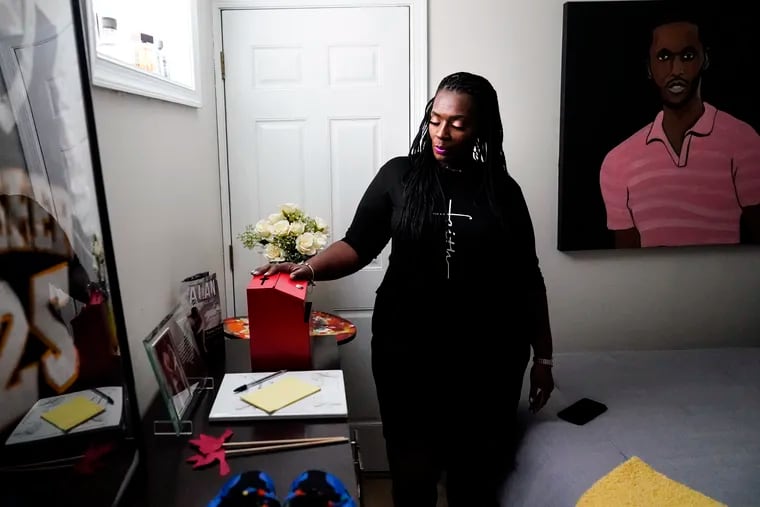 Latrice Felix, whose son, Alan Womack Jr., was killed in 2020 during a fight, places her hand on a box she leaves notes to him in, in King of Prussia.