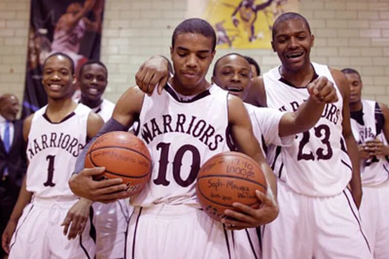 Maurice Watson is surrounded by teammates after he
scored his 2,000th point. (Michael S. Wirtz/Staff Photographer)