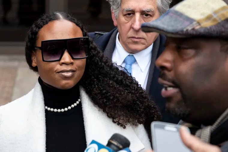 Dawn Chavous listens as Philadelphia City Councilmember Kenyatta Johnson talks with reporters as they leave the federal courthouse in Center City after pleading not guilty to federal corruption charges in January. Pictured in the background is Chavous' attorney, Barry Gross.