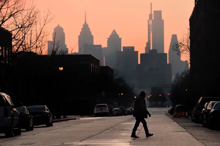 The sun sets behind the Philadelphia skyline and Market Street in Camden in late March.