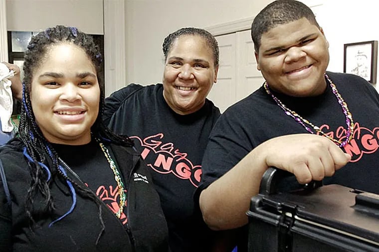 Mom Terrie Hawkins (center) and twins Keisha Diggs, (left) and Kevin Diggs volunteering at GayBINGO. The 17-year-olds will be honored this weekend as "Volunteers of the Year" by the AIDS Fund for their years of service. (Elizabeth Robertson/Staff Photographer)