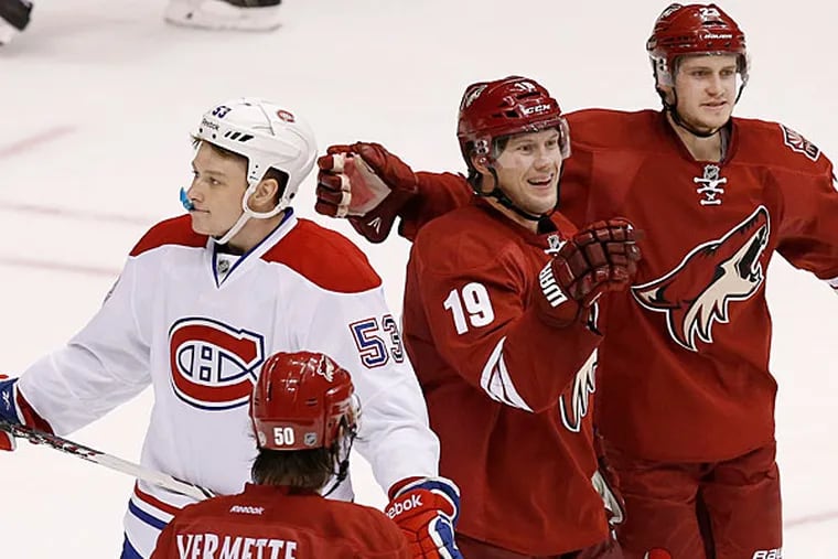 The Coyotes' Shane Doan (19) celebrates his goal with teammates Antoine Vermette (50) and Oliver Ekman-Larsson (23), of Sweden, as Montreal Canadiens' Ryan White (53) skates past during the third period of an NHL hockey game on Thursday, March 6, 2014, in Glendale, Ariz. The Coyotes defeated the Canadiens 5-2. (Ross D. Franklin/AP)