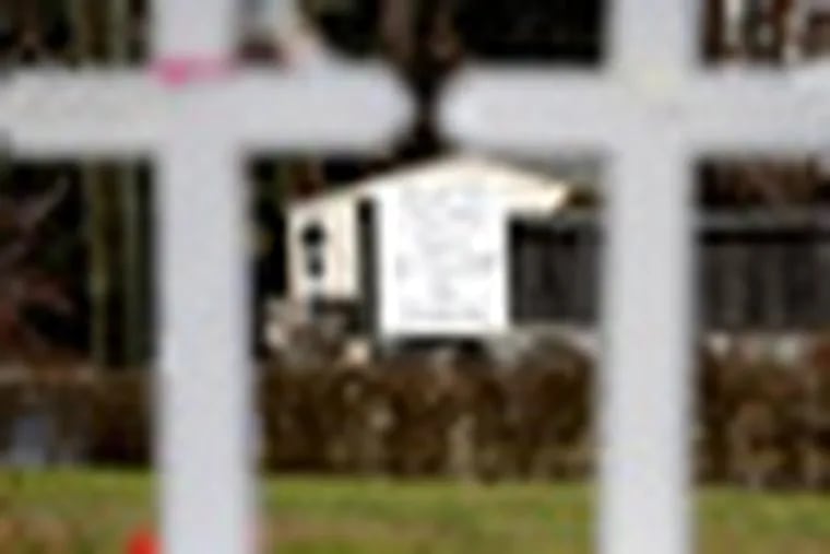A large sign is displayed across the street from crosses bearing the names of the Newtown shooting victims in the Sandy Hook village of Newtown, Conn., Saturday, Dec. 22, 2012.   The funerals for the victims of the school shooting are wrapping up after a wrenching week of farewells. Twenty children and six adults were killed at Sandy Hook Elementary School on Dec. 14.  Adam Lanza, the lone gunman, killed his mother before going on the rampage and then committed suicide. (AP Photo/Seth Wenig)