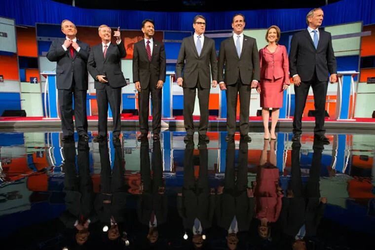 Republican presidential candidates, from left, Jim Gilmore, Lindsey Graham, Bobby Jindal, Rick Perry, Rick Santorum, Carly Fiorina and George Pataki take the stage for a pre-debate forum at the Quicken Loans Arena, Thursday, Aug. 6, 2015, in Cleveland. Seven of the candidates have not qualified for the primetime debate. (AP Photo/Andrew Harnik)