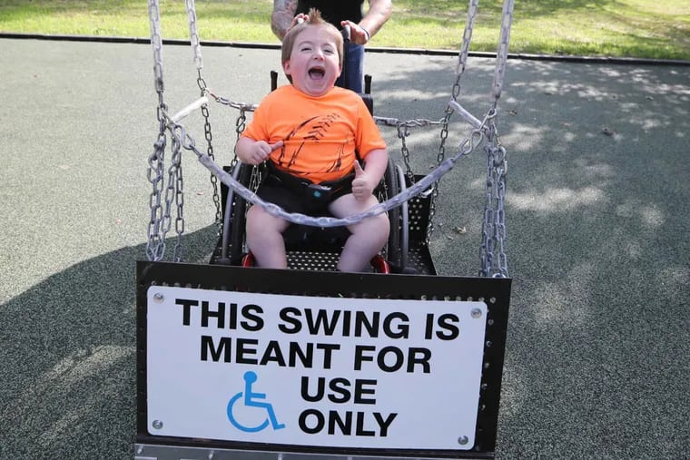 Joey Moore, 5, takes his first ride in the adaptive wheelchair swing at Oxford Memorial Park Playground.