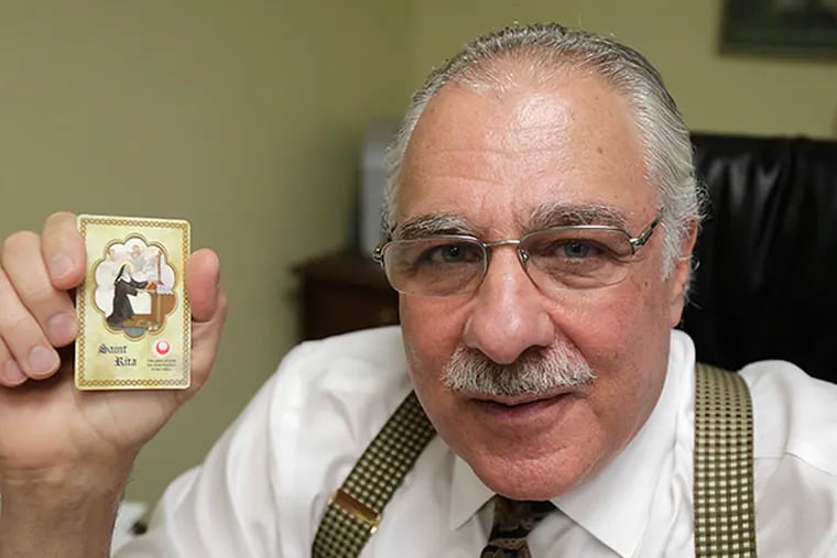 Donald Manno, a criminal defense attorney, successfully defended himself against criminal charges of racketeering and fraud. He is holding a Saint Rita's Holly Card, which he carried in his shirt pocket during the trial. ( AKIRA SUWA  /  Staff Photographer )