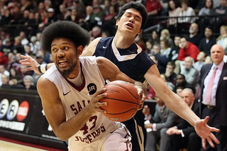 St. Joseph's #43 DeAndre' Bembry drives around George Washington's #12 Yuta Watanabe on his way to the basket for two points in the second half. (Michael Bryant/Staff Photographer)