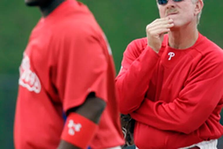 Phillies great Mike Schmidt (right), in Clearwater as an instructor, watches Ryan Howard as he works on a drill.