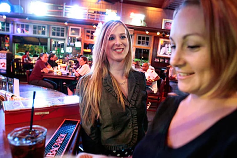 Melissa Galm (left) and Jessica Beavers at Chickie's & Pete's on Roosevelt Boulevard. Ten servers took part in the experiment. (Elizabeth Robertson / Staff Photographer)