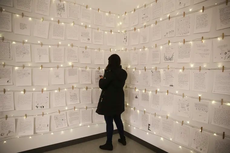 Raghva Saapi from Connecticut reads some of the hundreds of letters at the pop-up created by Brandon Doman at the Fashion District on Monday, Feb. 10, 2020.