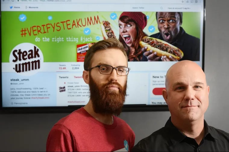 Nathan Allebach, left, and Jesse Bender at a computer monitor with the Twitter account for Steakumm at Allebach Communications.
