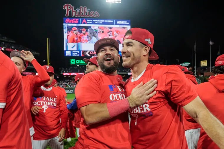 Kyle Schwarber (left) and J.T. Realmuto celebrate after the Phillies clinched a wild-card spot in the playoffs on Tuesday.