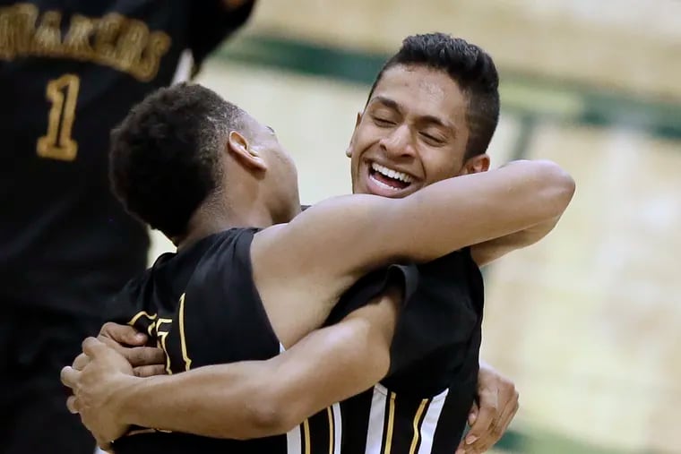 Moorestown seniors Nick Cartwright-Atkins (left) and Akhil Giri celebrate after the team's 64-44 win over Wall in the Group 3 state semifinals.