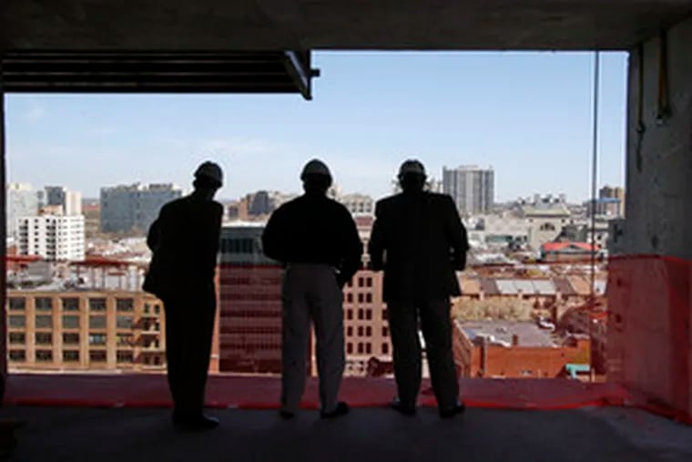 Michael Kuntz (right), regional manager of Turner Construction in Philadelphia, contemplates the view from the second floor of the Murano construction site at 21st and Market Streets. With him are Lehigh Weissman, safety manager at the site, and Luke Thomas, assistant to the regional general manager.