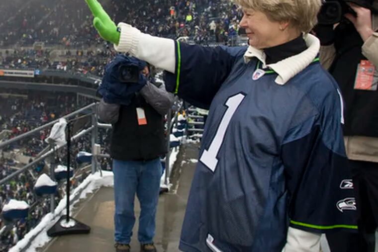 Kathy Holmgren, who specializes in diabetes, waves to the crowd after raising the &quot;12th Man&quot; flag at the home finale.