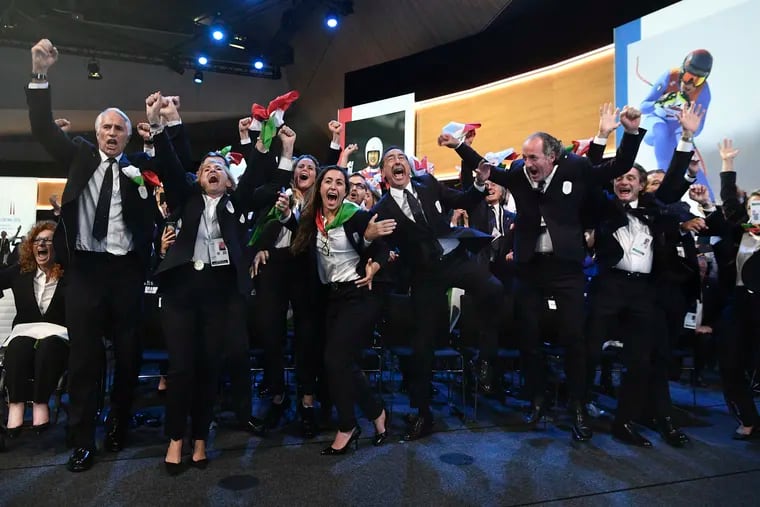 Italy's National Olympic Committee celebrates after winning the bid to host the 2026 Winter Olympic Games.