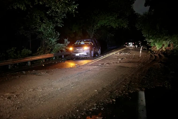 Mud and debris across the road where cars were swept up in flash flooding that occurred on Washington Crossing Road, near Houghs Creek, in Upper Makefield Township Saturday.