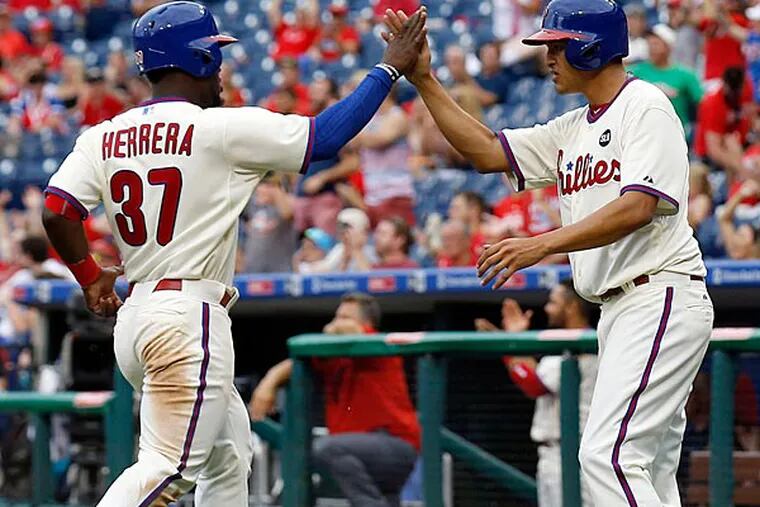 Severino Gonzalez and Odubel Herrera celebrate after scoring during game two of a doubleheader. (Yong Kim/Staff Photographer)