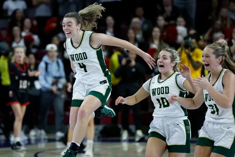 Archbishop Wood players (from left) Ava Renninger, Sophia Topakas, and Lauren Greer celebrate after beating Archbishop Carroll in double overtime to win the Philadelphia Catholic League girls’ basketball championship.