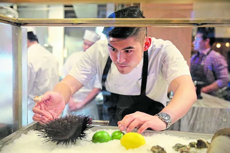 Chef-owner Kenneth Sze examines a live urchin at Tuna Bar in Old City.
