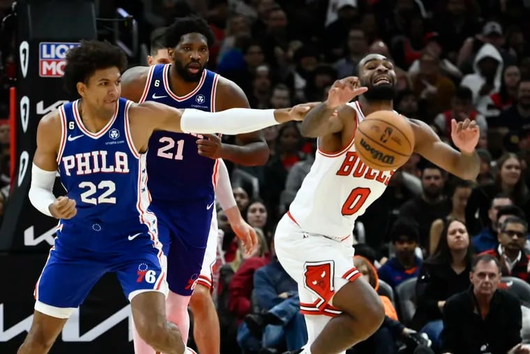 Chicago Bulls guard Coby White fights for a loose ball with Philadelphia 76ers guard Matisse Thybulle (22) and center Joel Embiid (21) during the second half of an NBA basketball game Saturday, Oct. 29, 2022, in Chicago. (AP Photo/Matt Marton)