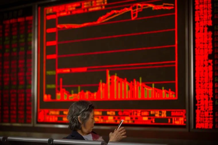 A Chinese investor uses her smartphone as she monitors stock prices at a brokerage house in Beijing, Friday, May 31, 2019. Asian shares were mixed Friday as trade worries continued after President Donald Trump announced additional tariffs on imports from Mexico. (AP Photo/Mark Schiefelbein)