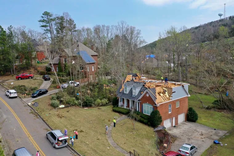 Repair work begins on heavily damaged homes along Eagle Point Drive in Birmingham, Ala., following a day of extended severe weather on March 26, 2021. (AP Photo/Vasha Hunt)