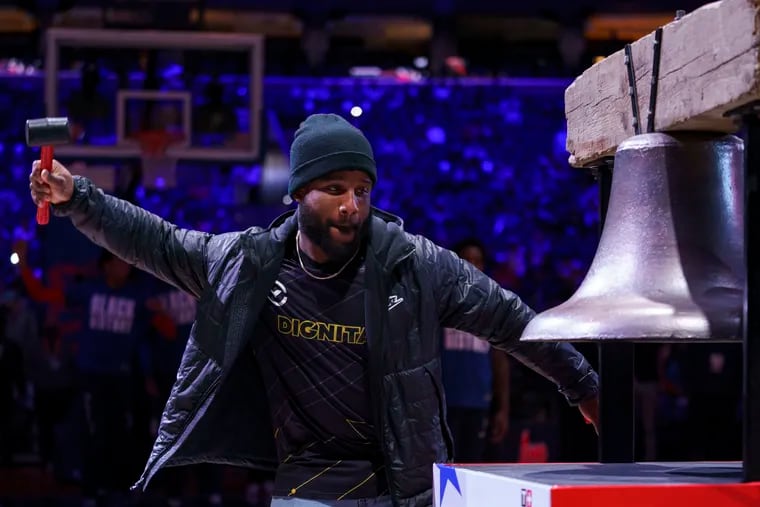 Boston Scott ringing the bell before a game between the Washington Wizards and the 76ers in February.