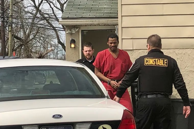 Zahkee Austin is escorted out of a magisterial district court in Lima after his preliminary hearing on attempted murder charges.