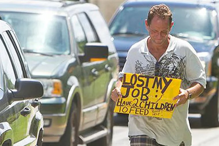 In a 2010 file photo, a man who did not wish to be identified, who lost his job two months ago after being hurt on the job, works to collect money for his family on a Miami street corner. The ranks of America's poor have climbed to a record high, according to new census data that paints a stark portrait of the nation's haves and have-nots at a time when unemployment remains persistently high. (AP Photo / J Pat Carter, File)