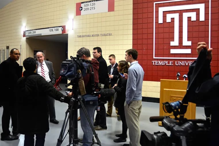 Spokesman Larry Dougherty (left), senior associate athletic director for communications at Temple University talks with the news media after a press conference December 6, 2013 to talk about the school's cutting seven of its 24 intercollegiate sports programs. (Tom Gralish/Staff Photographer)