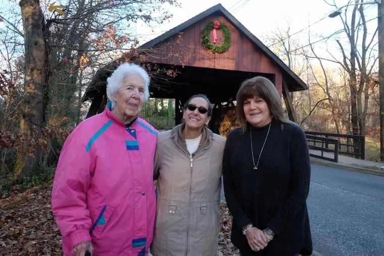 Sally Callaghan (from left), neighbor Mimi Cowperthwaite and Callaghan&#039;s daughter Joanne Mitchell have decorated the Scarborough Covered Bridge with Christmas wreaths for 23 years.