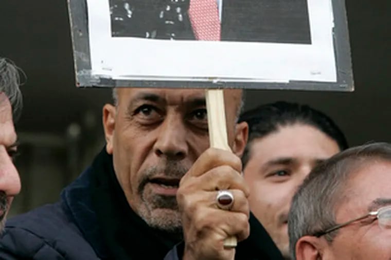 At a rally in Jordan in support of shoe-throwing journalist Muntadhar al-Zeidi, a sign illustrates the Iraq incident.