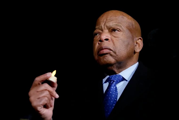 U.S. Rep. John Lewis holds a candle during an event on Jan. 30, 2017, in front of the Supreme Court in Washington, D.C.