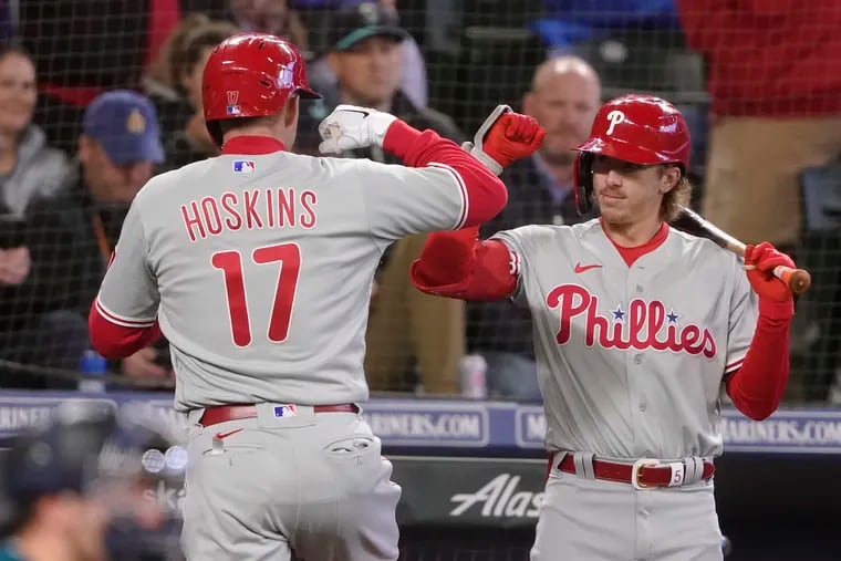 Philadelphia Phillies' Rhys Hoskins (17) is greeted by Bryson Stott, right, after hitting a solo home run during the second inning of a baseball game against the Seattle Mariners, Monday, May 9, 2022, in Seattle. (AP Photo/Ted S. Warren)
