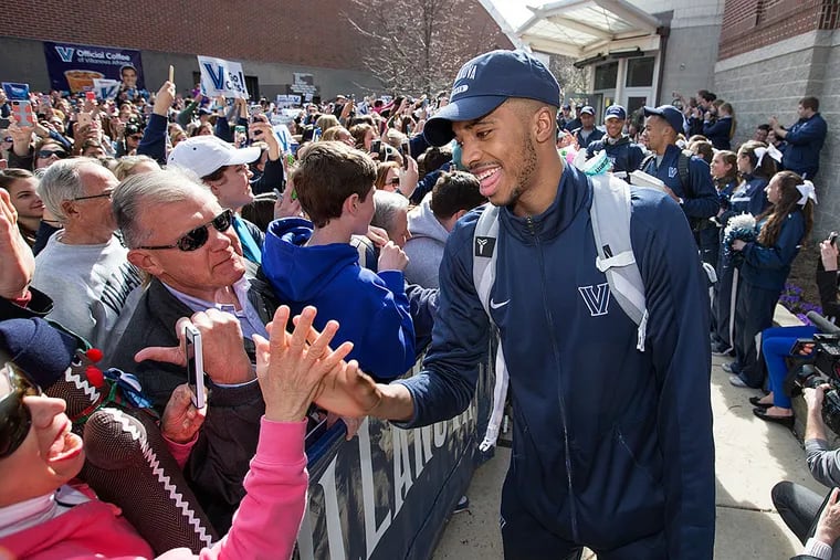 Villanova's Mikal Bridges and other team members make their way through the fans.