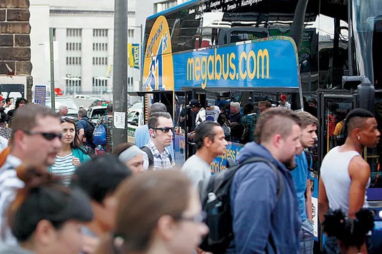People board Megabus buses at the station on JFK Boulevard on Tuesday afternoon. Intercity buses such as Megabus and Bolt are reversing a decades-long decline in the industry and have made a national comeback in the past five years. (LUKE RAFFERTY/Staff Photographer)