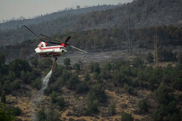A Chinook helicopter fills up with water to release on the Lake Christine Fire, Saturday, July 7, 2018 in Basalt, Colo.
