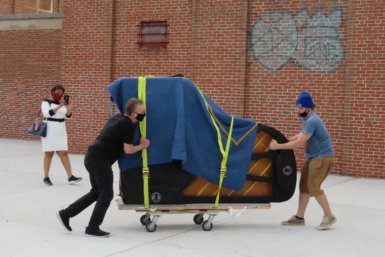 Employees of St. Louis Piano deliver a donated grand piano to a community center in St. Louis earlier this year.