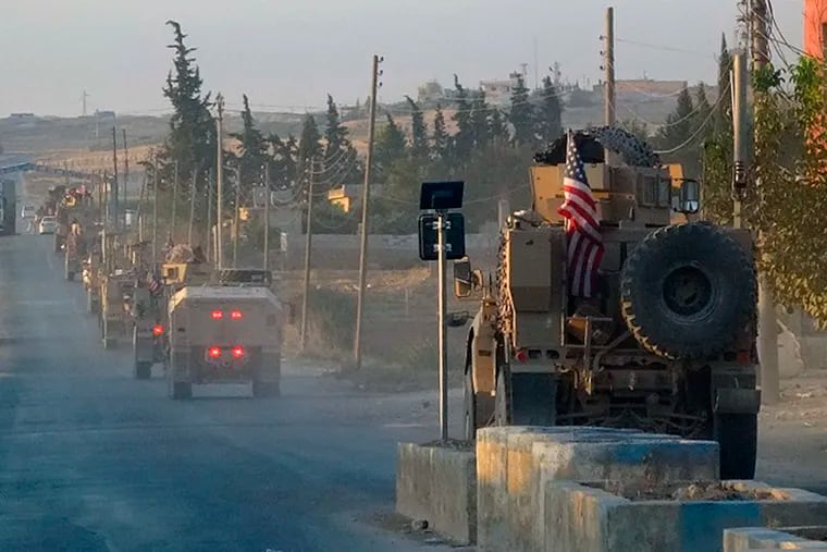 In this image provided by Hawar News Agency, ANHA, U.S. military vehicles travel down a main road in northeast Syria, Monday, Oct. 7, 2019. U.S.-backed Kurdish-led forces in Syria said American troops began withdrawing Monday from their positions along Turkey's border in northeastern Syria, ahead of an anticipated Turkish invasion that the Kurds say will overturn five years of achievements in the battle against the Islamic State group. (ANHA via AP)
