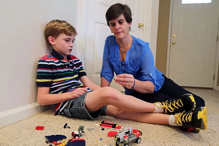 Lori Paul, right, sits with her son Max Paul, 9, at their Orlando, Fla., home, Jan. 13, 2014. The Paul Family uses a computer and smartphone to log into their son Max's health records. Max has cystic fibrosis. Technology brings them faster answers, and lessens anxiety in waiting for test results. (Ricardo Ramirez Buxeda/Orlando Sentinel/MCT)