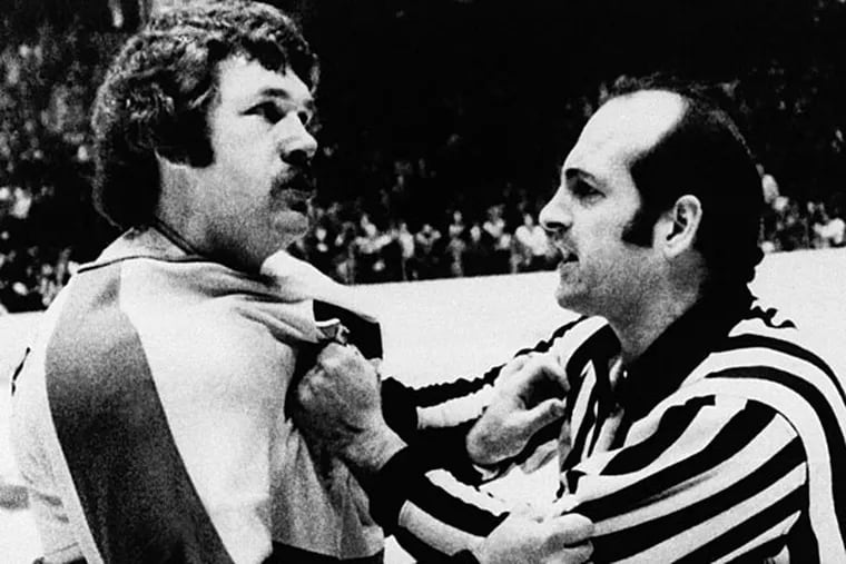 Dave "The Hammer" Schultz, of the Philadelphia Flyers, is restrained by a linesman as he tries to continue a fight that had been halted. Schultz was the most penalized man in the National Hockey League in 1975, mostly due to fighting. (Rusty Kennedy/AP file)