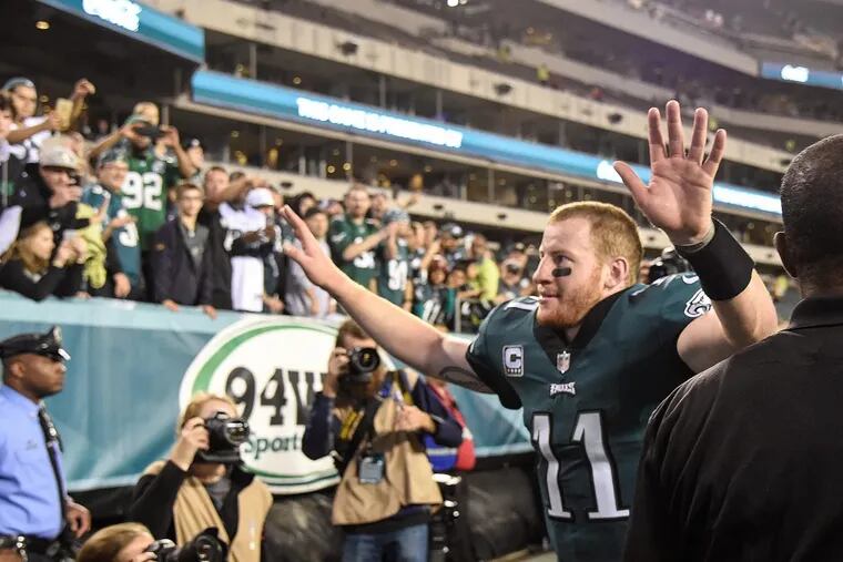 Philadelphia Eagles quarterback Carson Wentz waves his arms to the fans as he leaves the field after the Eagles beat the Redskins.