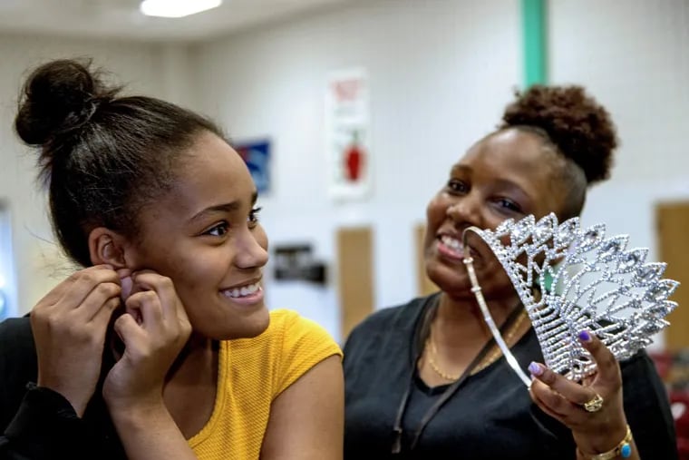 Haneefah McCrary (right) holds the East Coast USA Pageant crown for her daughter Aliyana McCrary, 13, as she puts it on at her William Penn Middle School in Yardley May 1, 2018.