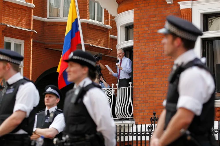 In this Aug. 19, 2012 file photo, surrounded by British police, WikiLeaks founder Julian Assange, center, makes a statement to the media and supporters from a window of the Ecuadorian Embassy in central London. Police in London arrested WikiLeaks founder Assange at the Ecuadorean embassy Thursday, April 11, 2019 for failing to surrender to the court in 2012, shortly after the South American nation revoked his asylum.