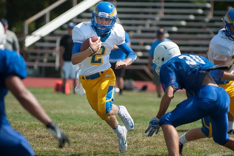 Senior quarterback Matt Widmaier runs with the ball for Pennsville Memorial High School during a scrimmage at Triton Regional High School in Runnemede, N.J. on Tuesday, Aug. 25, 2015. Pennsville's team has dedicated their season to injured friend and player Kyle Pszenny.