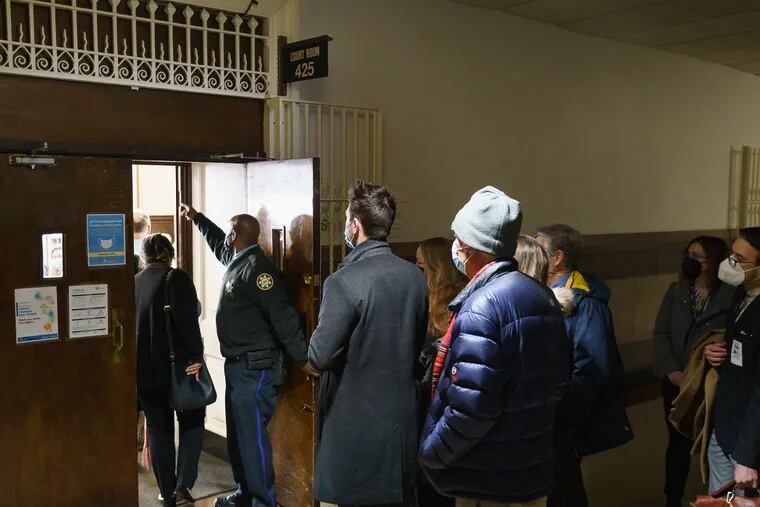 People wait outside in the hall prior to the start of a packed Feb. 28 court hearing to decide if the city can legally transfer the priceless collection of the Philadelphia History Museum to Drexel, Monday, February 28, 2022.