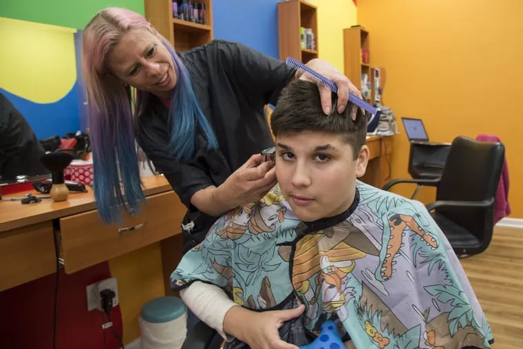 Sean Smith, who has autism, gets his hair cut at Wiggle Worms Children’s Hair Studio by owner/operator Kira Ferguson who has special training in working with autistic children.