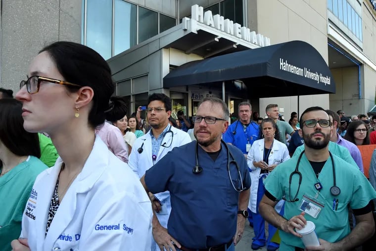 Hospital workers listen as Democratic presidential candidate Sen. Bernie Sanders speaks at a rally July 15 at Hahnemann University Hospital, railing against its closure and citing it as an example of why the country needs his Medicare for All plan.