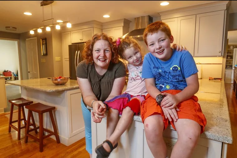 Before a redesign, the 1950s-era kitchen of the Cape Cod in Devon had barely enough space to turn around. Now, Monica Church (left) and daughter, Nora, 3, and son, James, have ample space.
